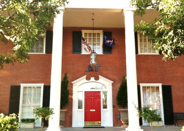 USC DG house, red brick, tall columns, red door, black shutters and white trim